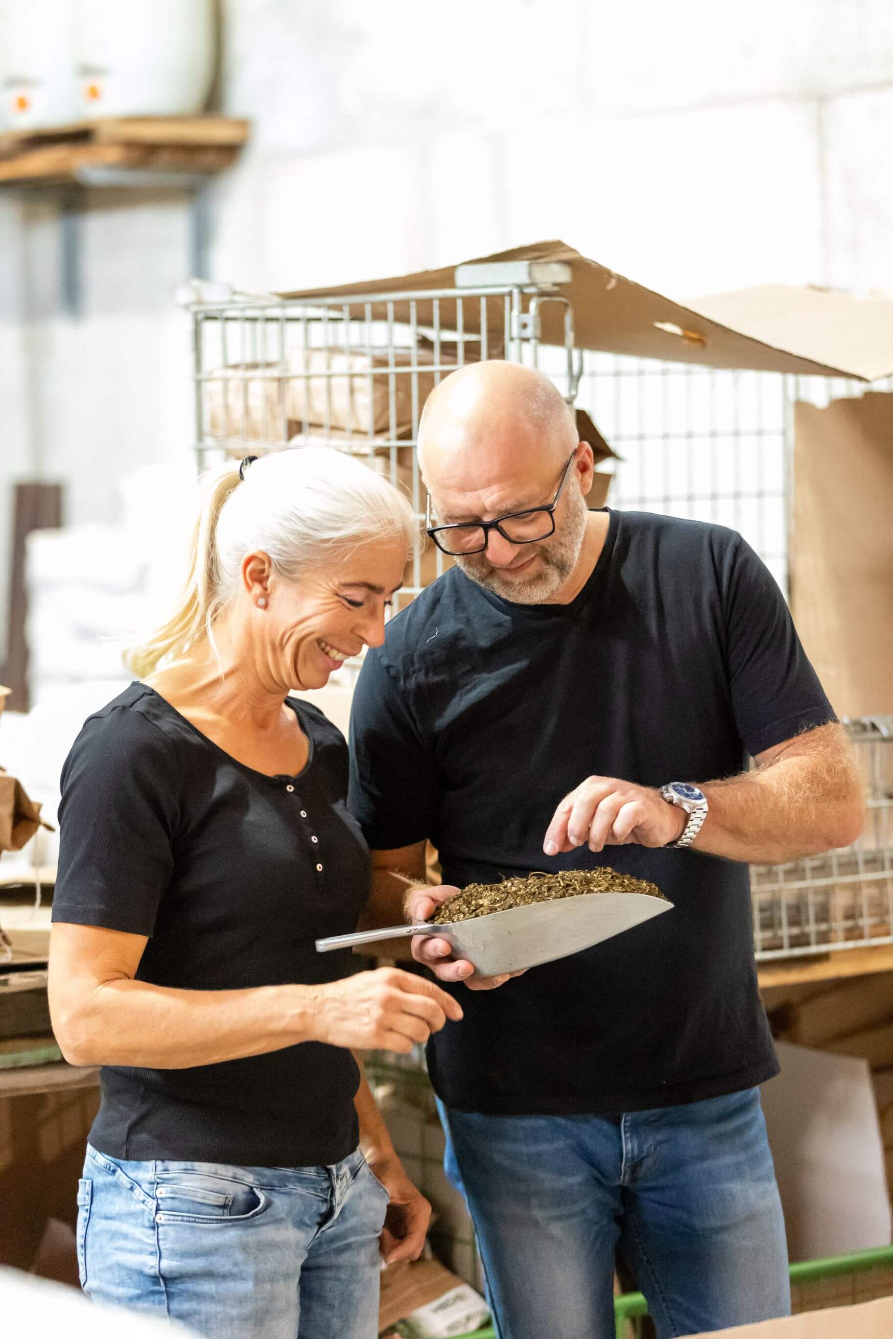 Anja und Heiner Beifuss begutachten gemeinsam eine Schaufel mit Futterrohstoffen im Lager