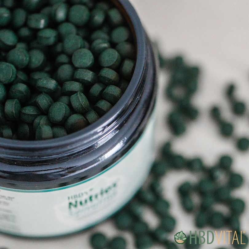 Geöffnetes Glas mit grünen Spirulina-Tabletten, hochwertige Nahrungsergänzung